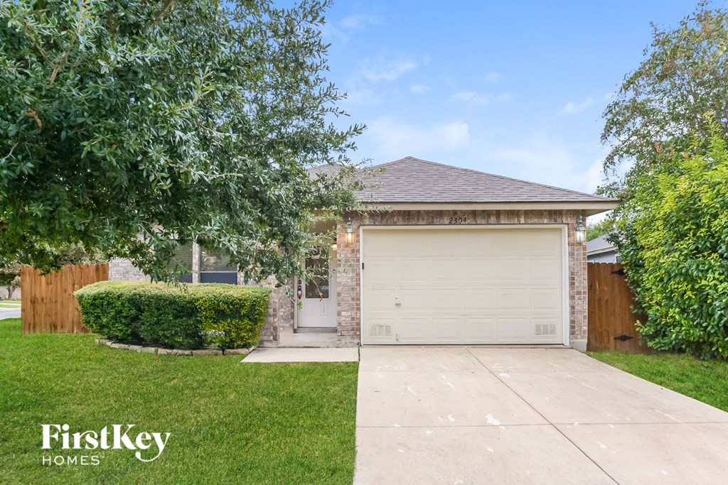 a small brick house with a white garage door