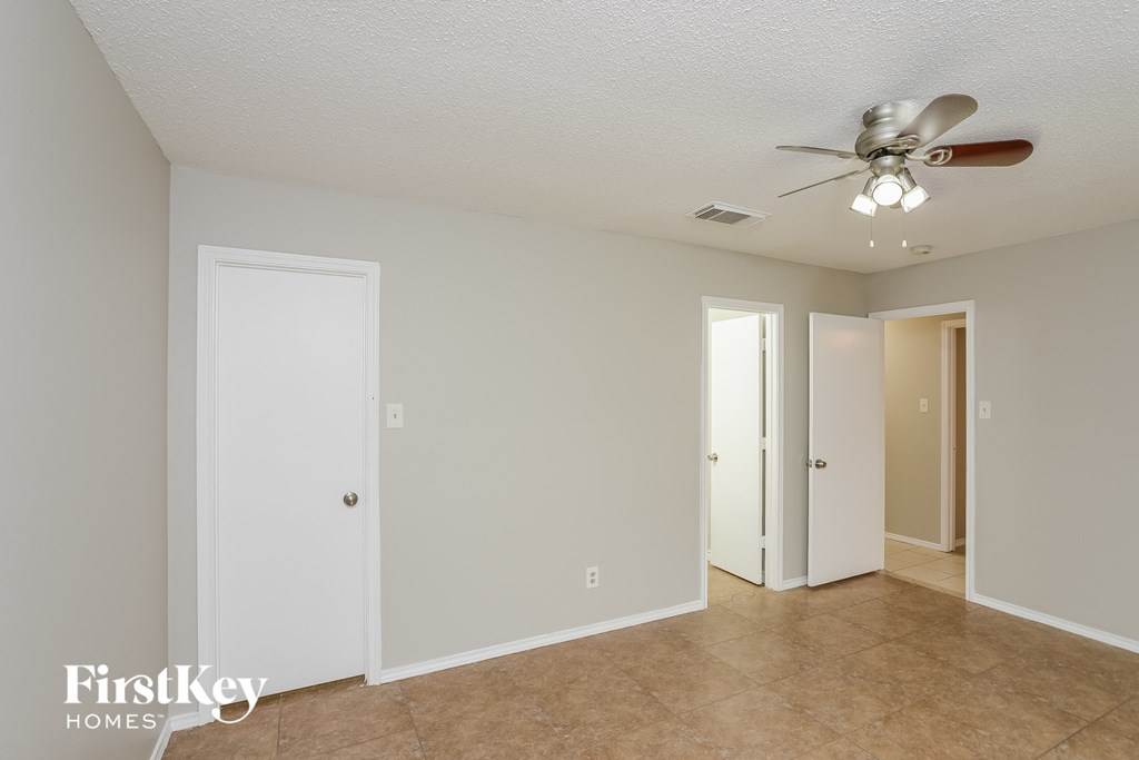 a living room with a ceiling fan and a door to a closet