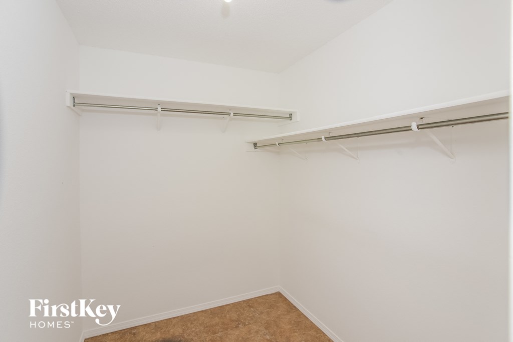 a bedroom with two hanging rails on the wall and a carpeted floor