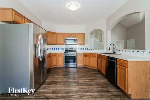 A kitchen with wooden cabinets and a refrigerator.