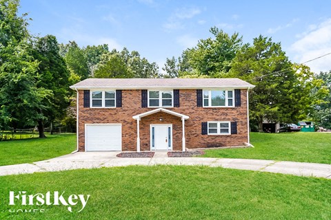 a brick house with a white door and a green lawn