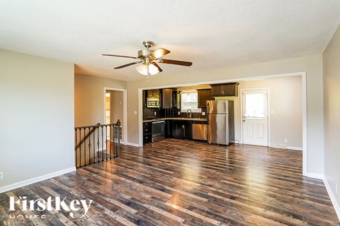 a kitchen and living room with hardwood floors and a ceiling fan