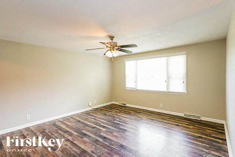 a bedroom with hardwood floors and a ceiling fan
