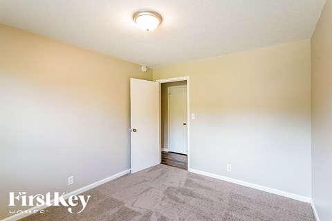 a living room with carpet and a door to a hallway