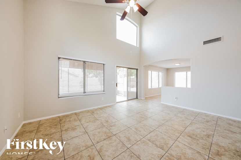 A spacious room with a fan and tiled flooring.