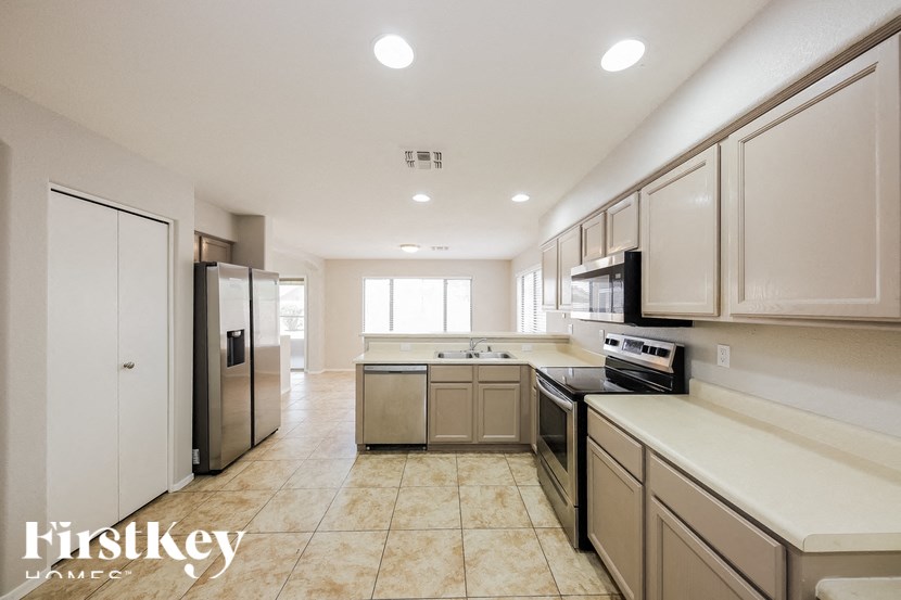 A kitchen with beige cabinets and a tiled floor.