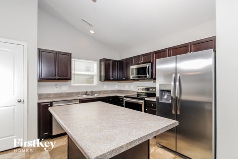 A kitchen with a granite countertop and stainless steel appliances.