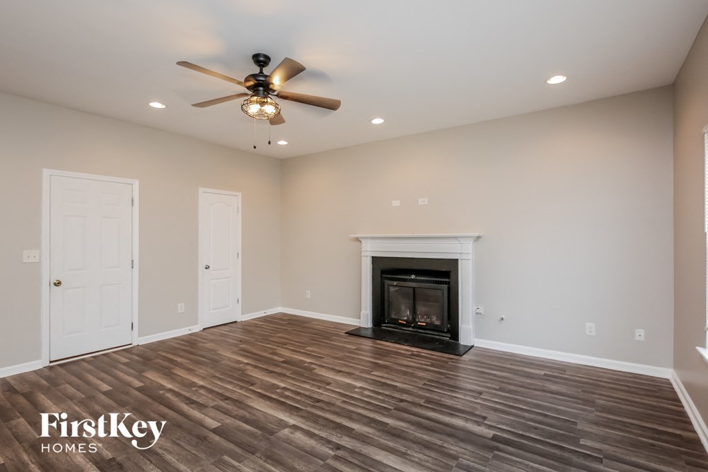 a living room with a fireplace and a ceiling fan