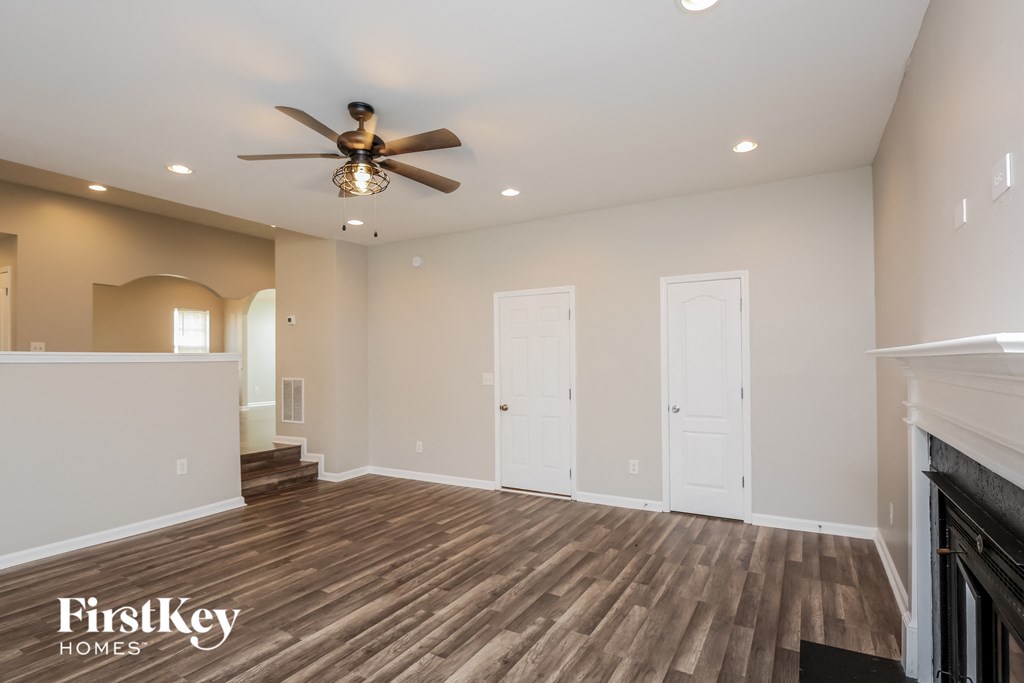 a living room with wood flooring and a ceiling fan