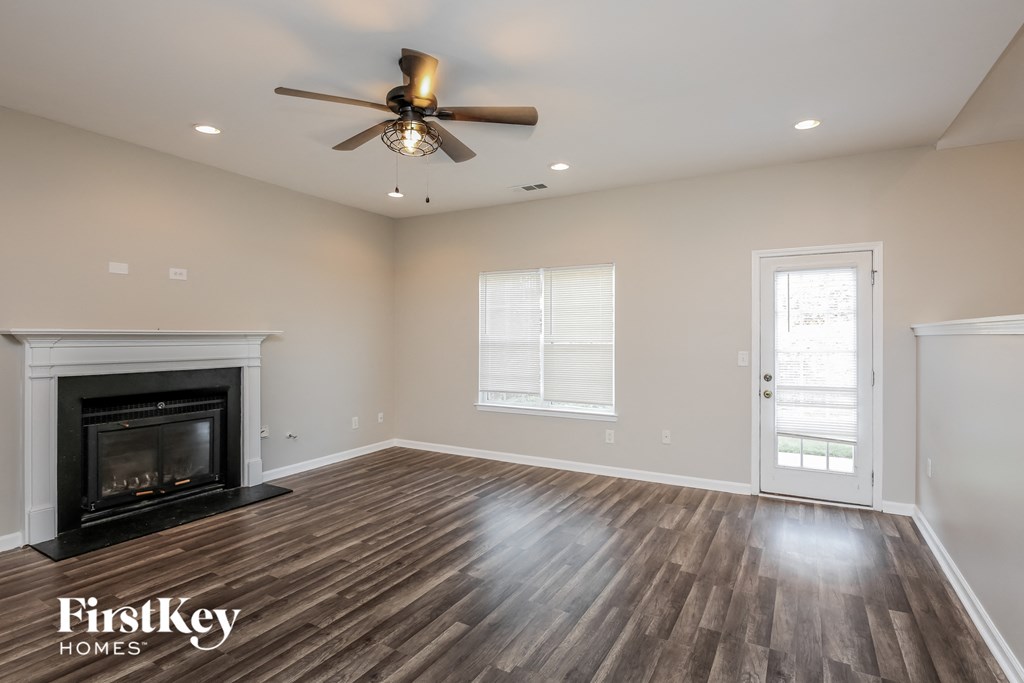 a living room with a fireplace and a ceiling fan