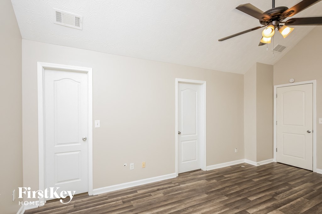 a living room with two doors and a ceiling fan