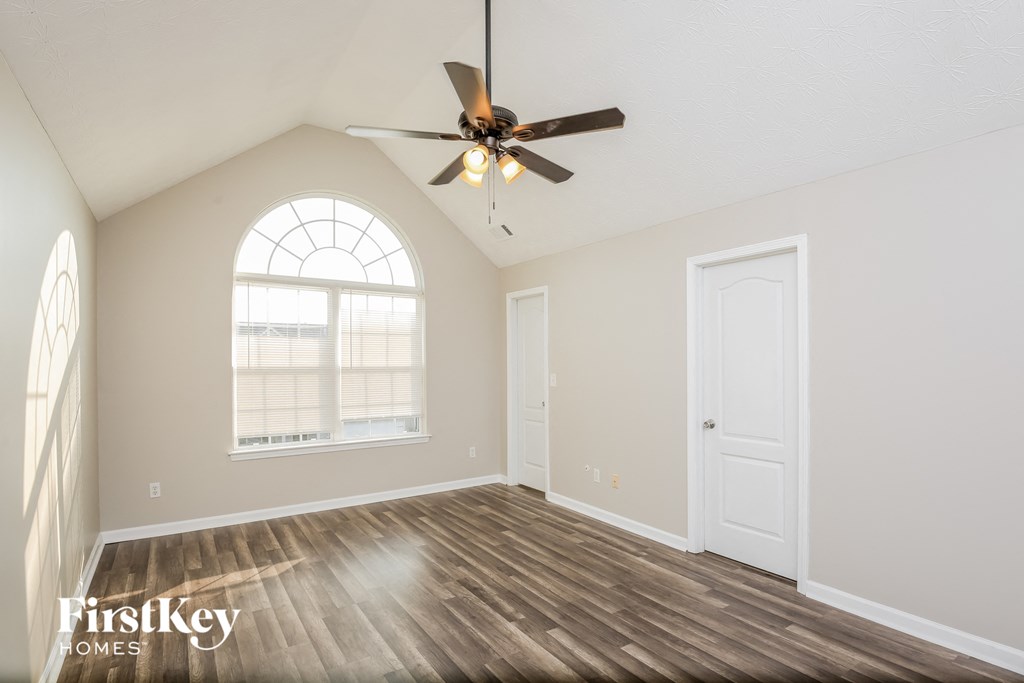 the living room of an empty house with a ceiling fan