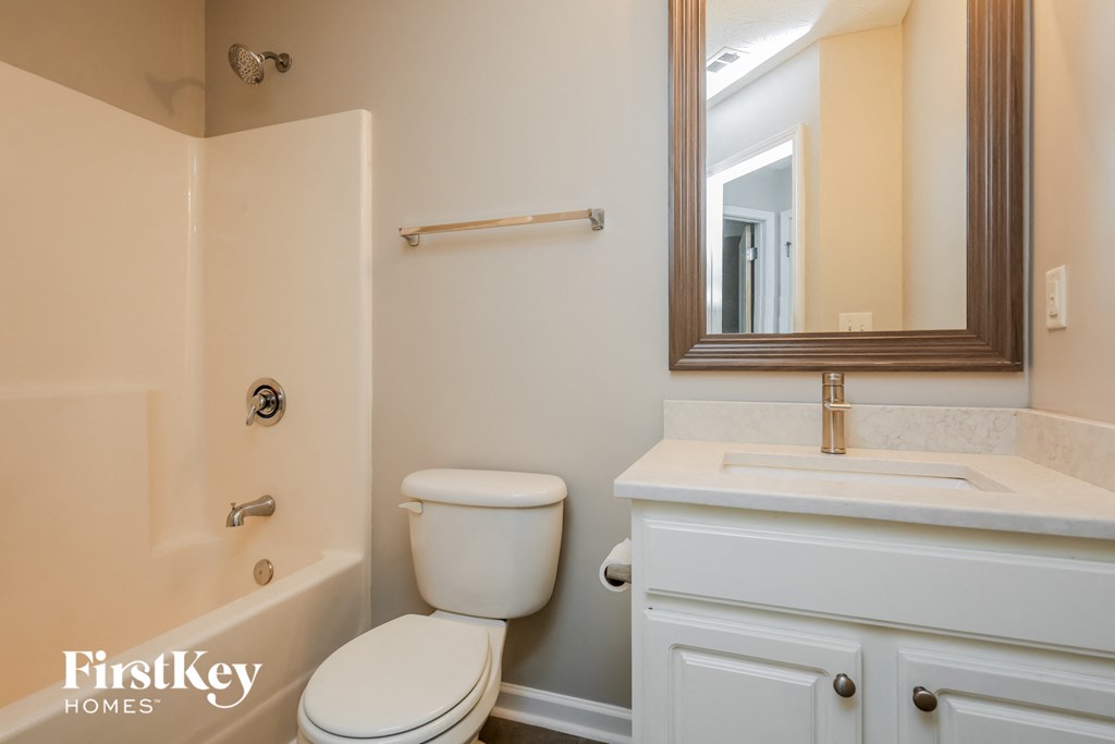 a bathroom with a toilet and a sink and a mirror