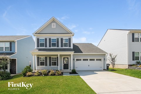 a blue house with a white garage door and a lawn