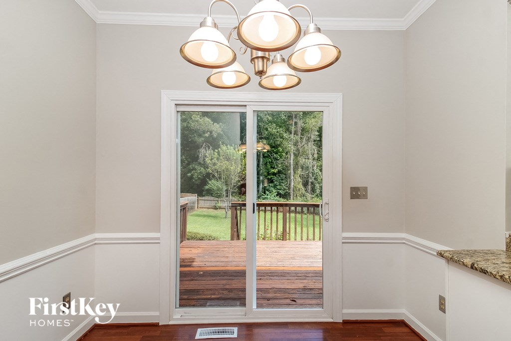 a view of the backyard from the dining room with a door to the deck
