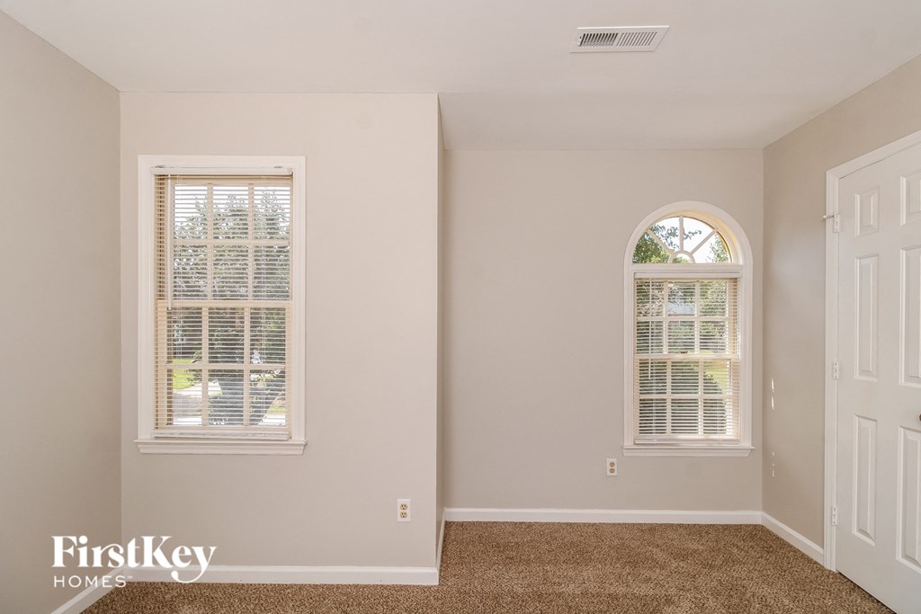 an empty room with a window and a white door