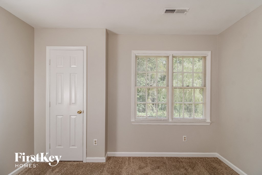 a bedroom with a white door and a window