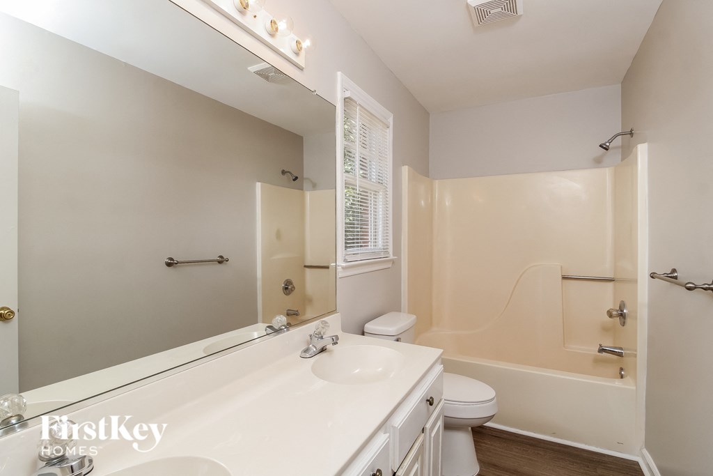a bathroom with a large mirror and a sink and a toilet