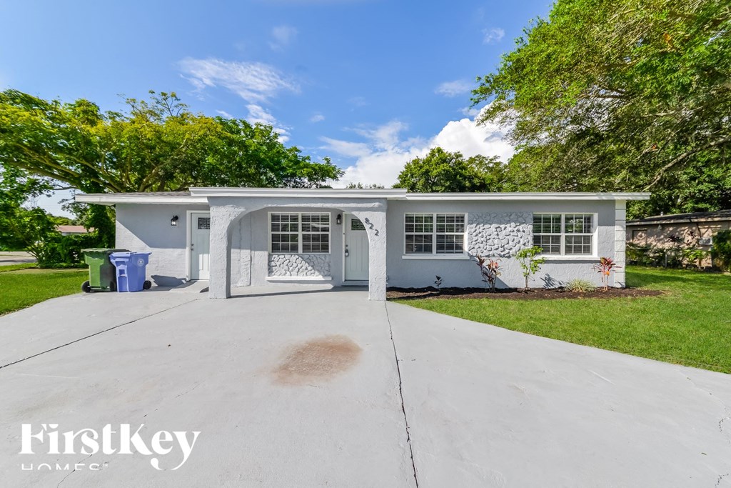 a white house with a garage and a stain on the driveway