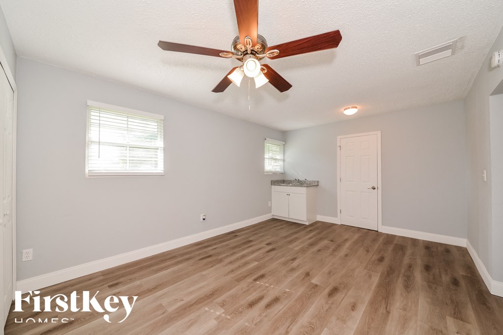 the living room and dining room with a ceiling fan