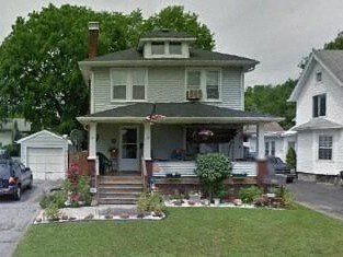 a house with a porch and a car parked in front of it