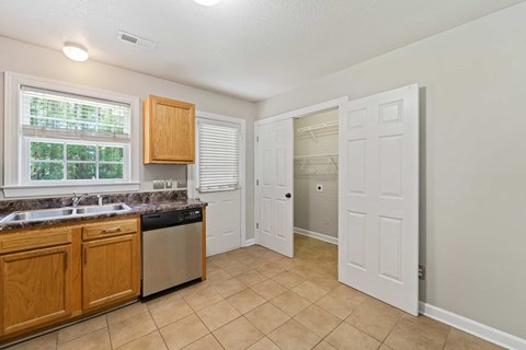 A kitchen with wooden cabinets and a window.
