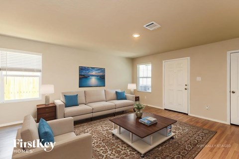 A living room with a couch, a coffee table, and a painting on the wall.