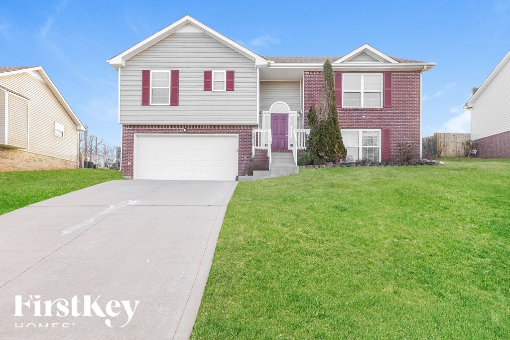a brick house with a white garage door and a green lawn