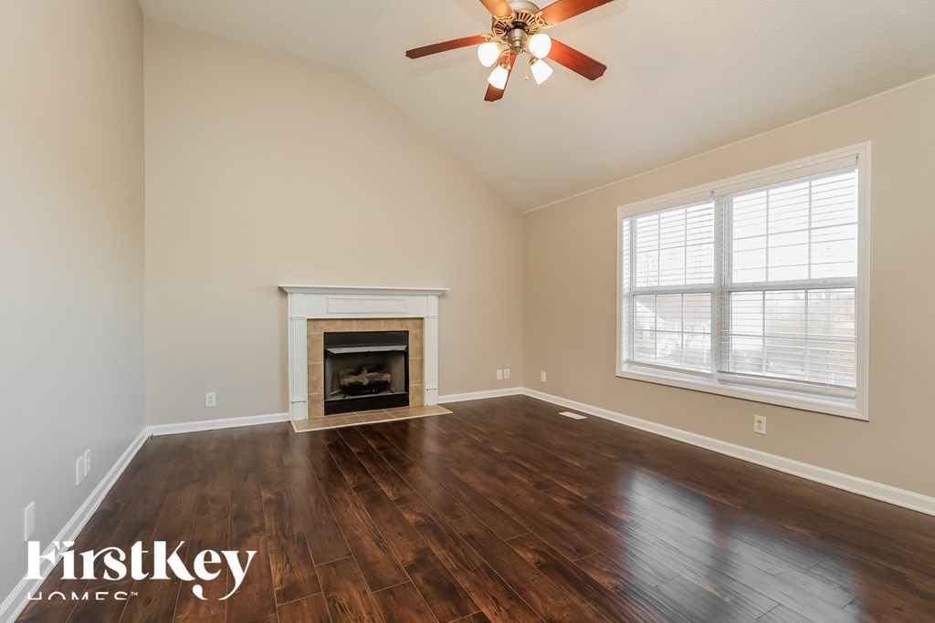 the living room has a fireplace and hardwood floors