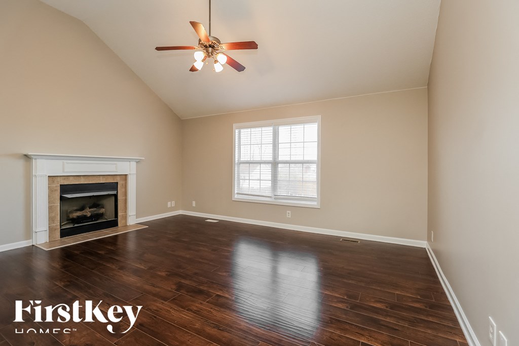 a living room with a fireplace and a ceiling fan
