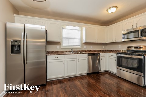 a kitchen with stainless steel appliances and white cabinets