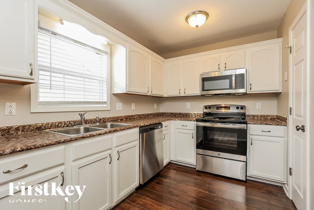 a kitchen with white cabinets and stainless steel appliances