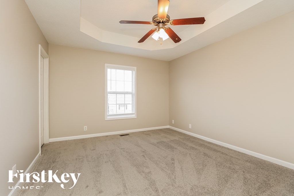 a bedroom with carpet and a ceiling fan