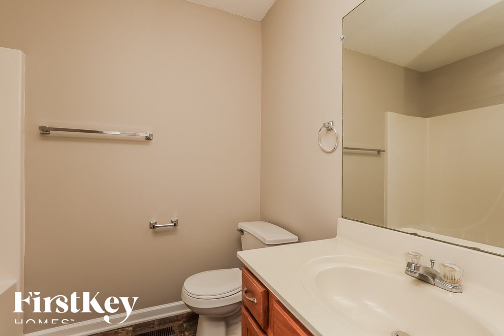 a bathroom with a sink toilet and a mirror