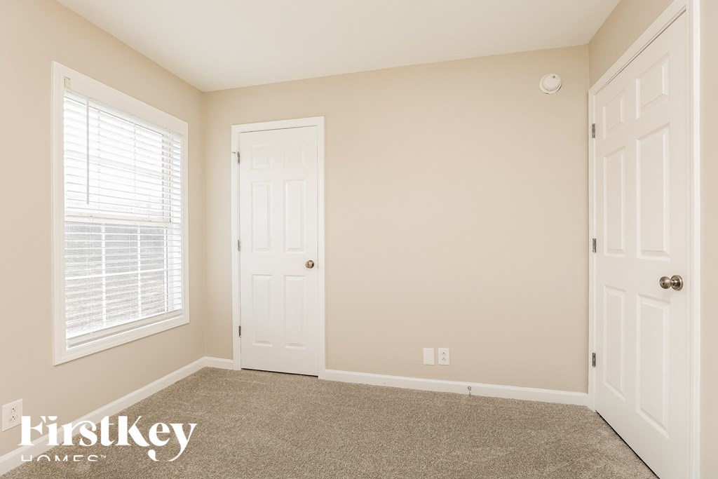 a bedroom with a carpeted floor and a white door