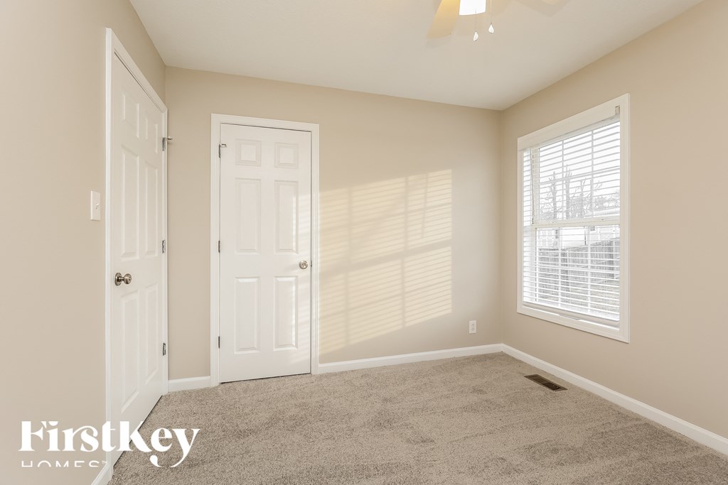 a bedroom with a carpeted floor and a white door