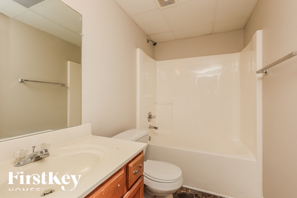 a bathroom with a toilet and a sink and a tub