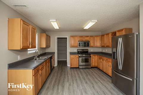 A kitchen with wooden cabinets and a stainless steel refrigerator.