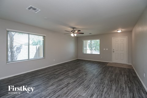 the living room of an empty house with a ceiling fan