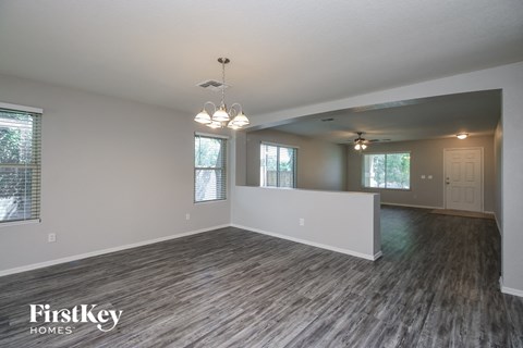 the living room and dining room of an empty house