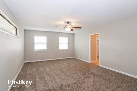 a living room with carpet and a ceiling fan
