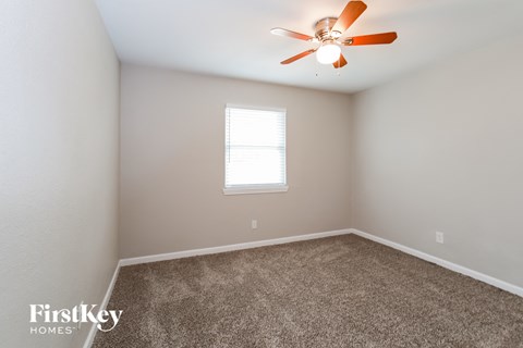 a bedroom with carpet and a ceiling fan