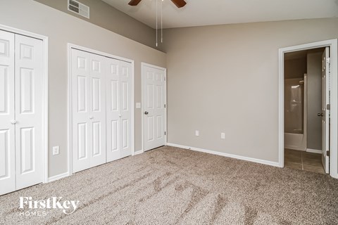 a bedroom with two closets and a carpeted floor
