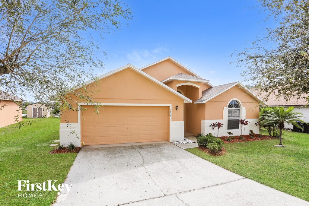 a beige house with a driveway and a garage door