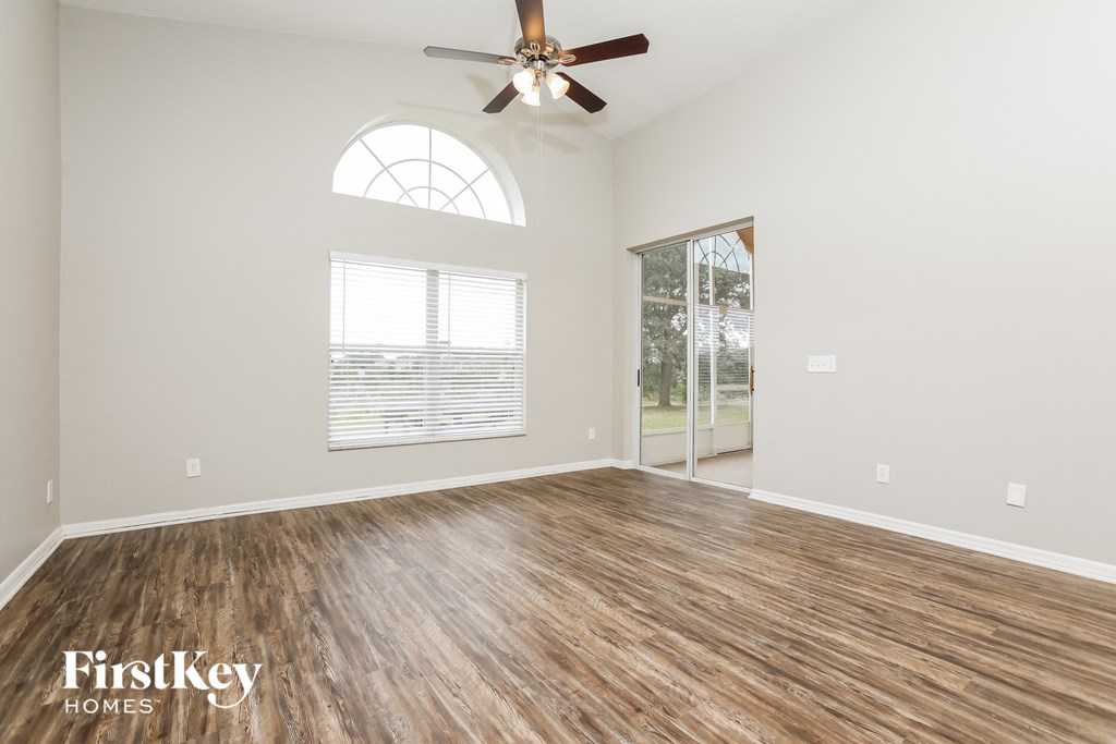 the living room of an empty house with a ceiling fan