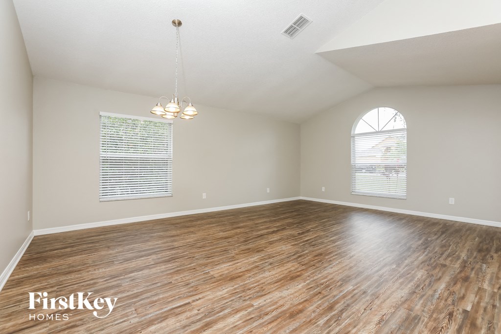 the spacious living room with wood flooring and a large window