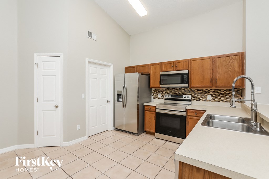 a kitchen with a stainless steel refrigerator and a sink