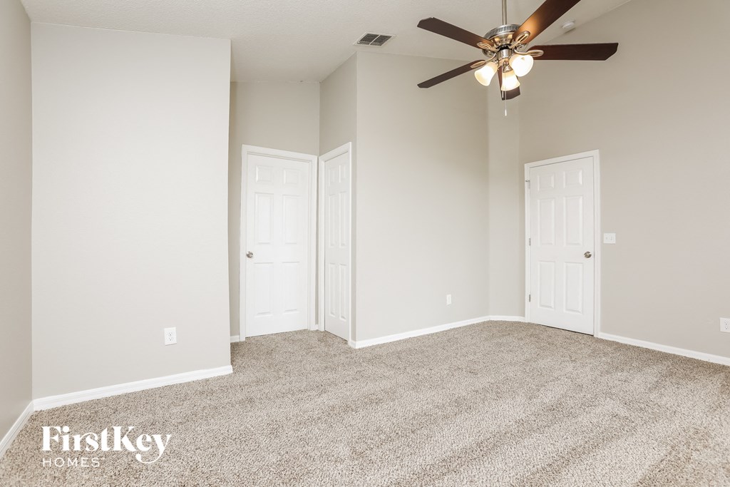 a bedroom with carpet and a ceiling fan