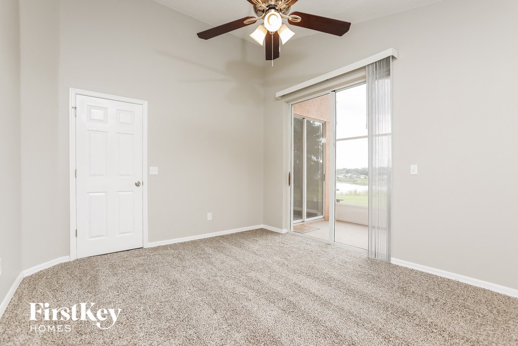 the living room of an empty house with a ceiling fan