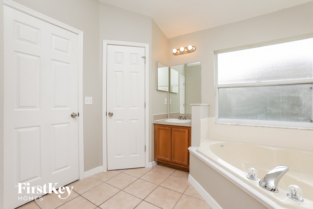 a bathroom with a tub and a sink and a window